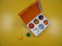 Molde con tapa y con seis huecos en los que hay distintas bolas de colores.