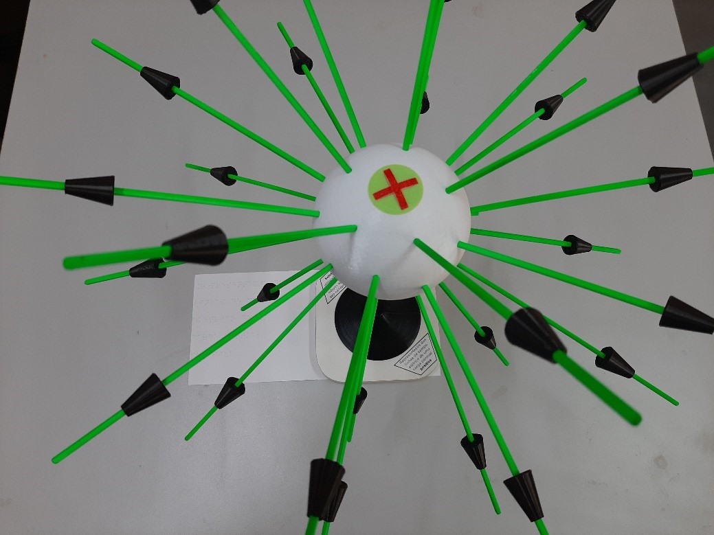 A maquete descreve portadores esf�ricos de carga el�trica positiva e as linhas de for�a dos campos el�tricos por eles gerados.