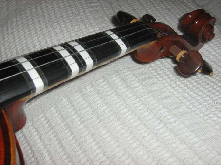 7. As fitas adesivas e colocadas no braço do violino de forma tradicional
